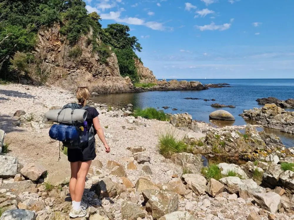 A hiker on the rugged coast along the Bornholm Coastal Path