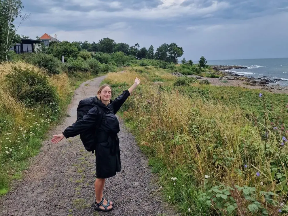 A hiker on the Bornholm Coastal Path with a view of the baltic sea.