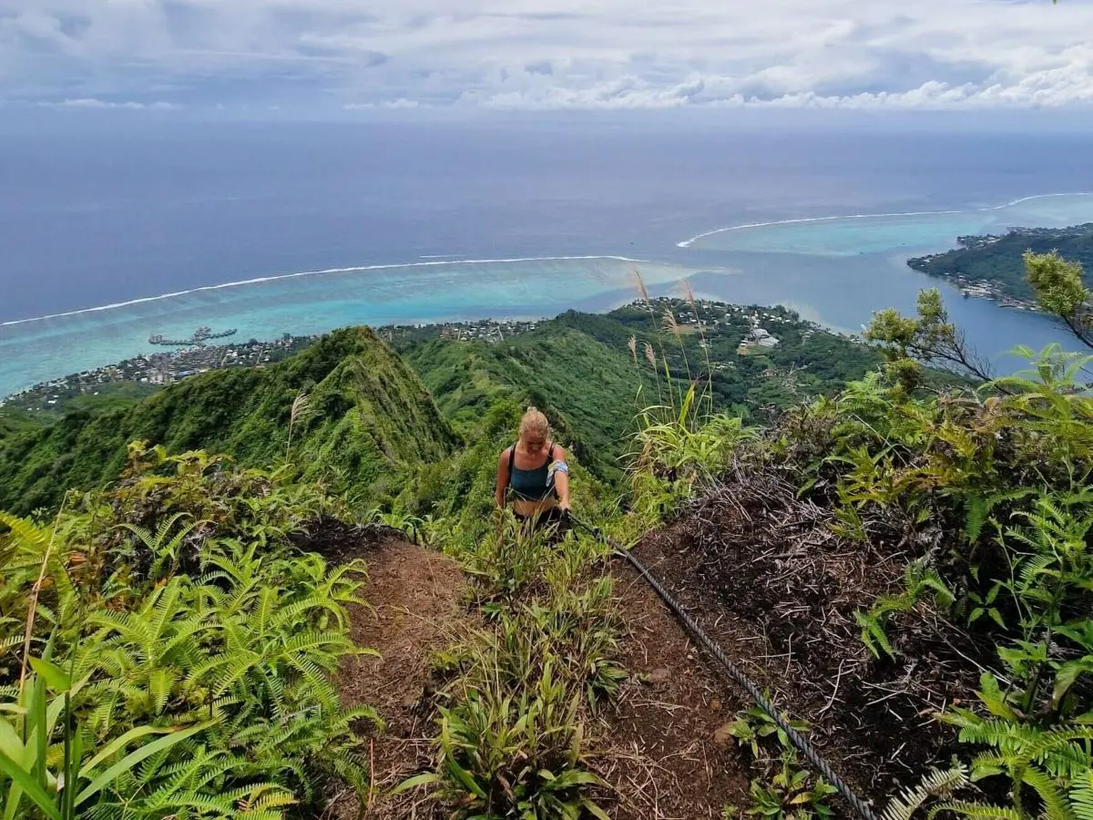 Hiker using ropes on the best hike in Moorea - the Mount Rotui Hiking Trail