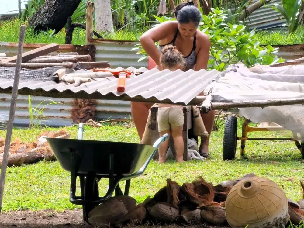 Mica's wife and daugther working at their plantage at home on a motu in Bora Bora