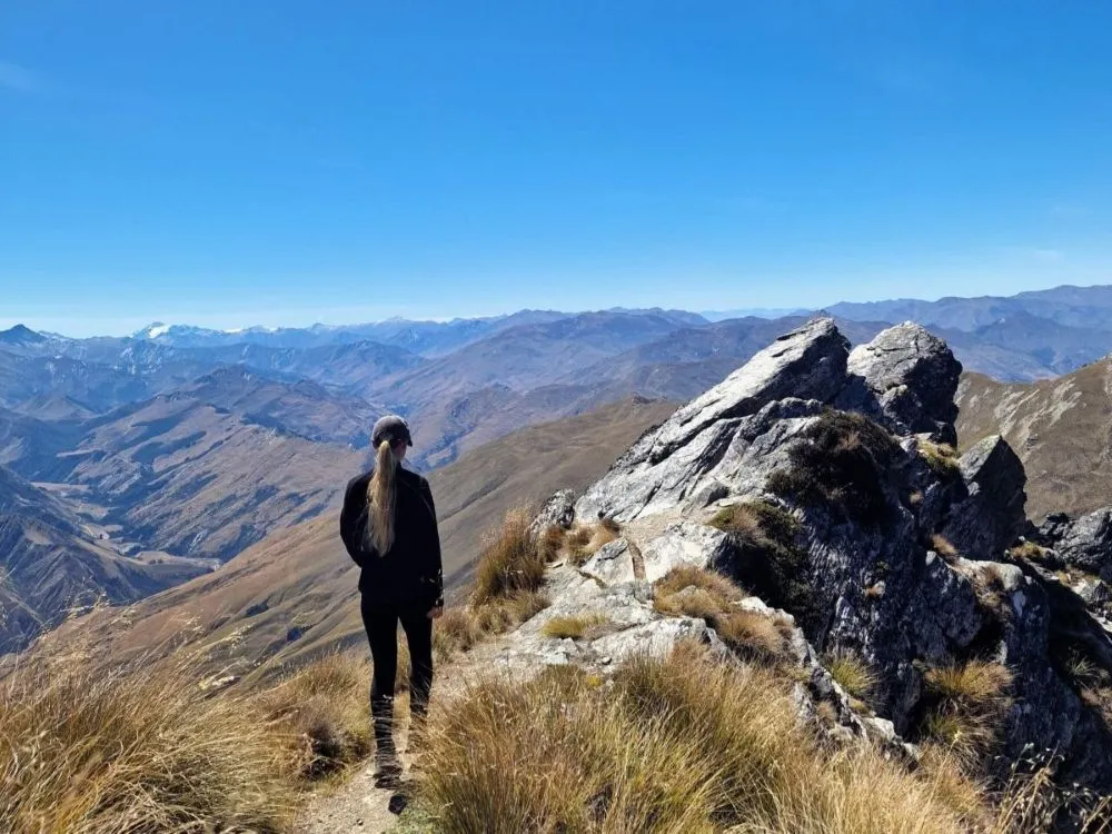 A solo female hiker on the Ben Lomond Track via Tiki Trail in Queenstown, New Zealand