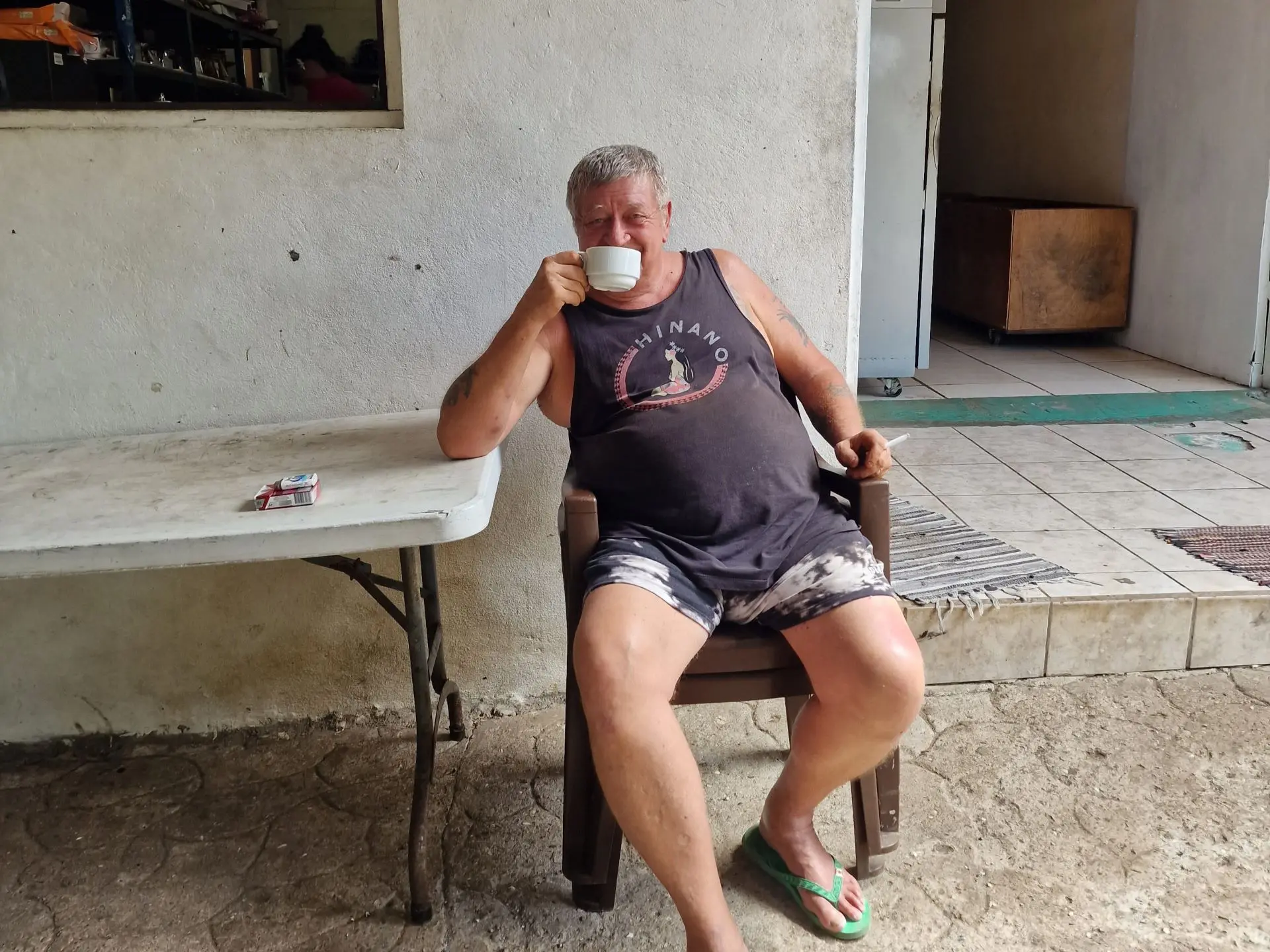 Brian, the ex-legionnaire from the French Foreign Legion, sits in a plastic chair at his vanilla farm in Taha'a, sipping a coffee