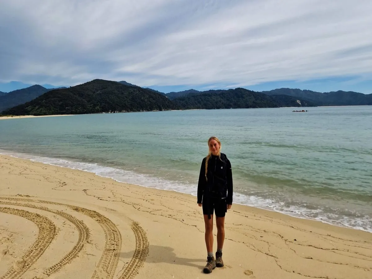 A solo female traveler hiking the Abel Tasman Coast Track in New Zealand