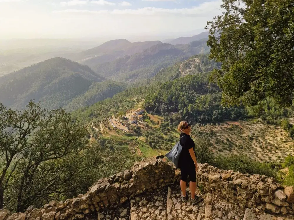 A hiker on the Alaro Castle trail leading to old ruins and the best lamb restaurant in Mallorca